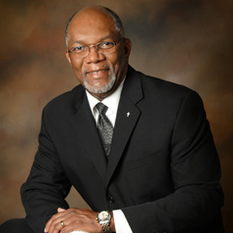 A man in a suit and tie sitting down.