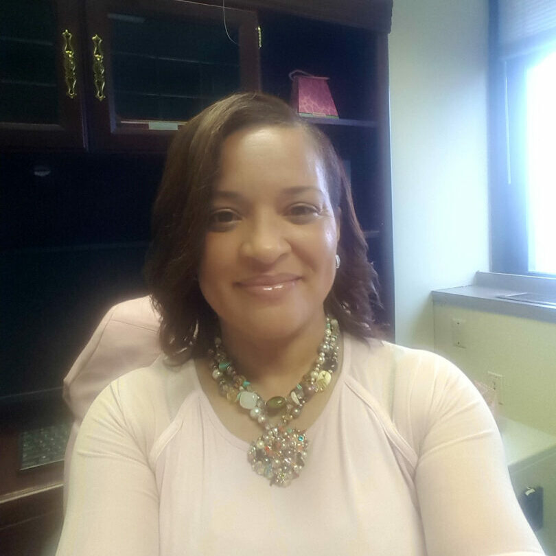 A woman in a white shirt and necklace